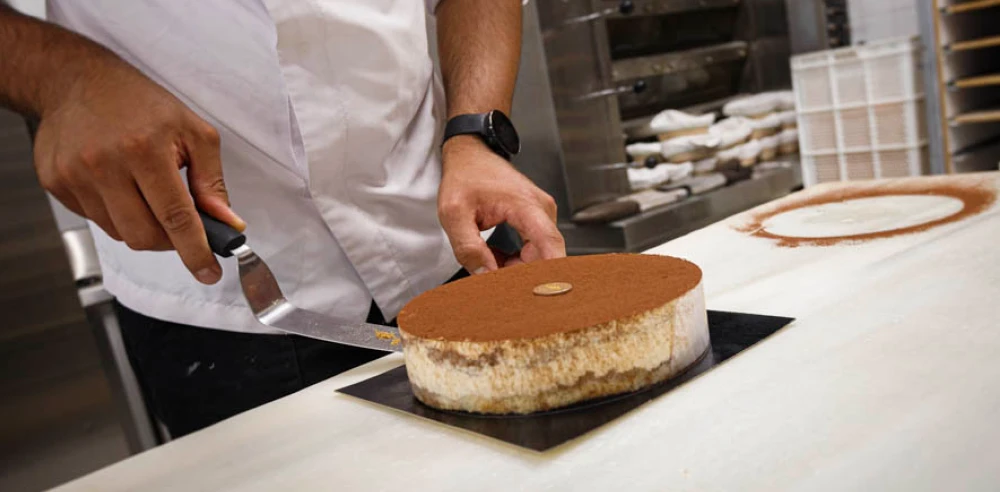 Pastelero terminando una tarta.